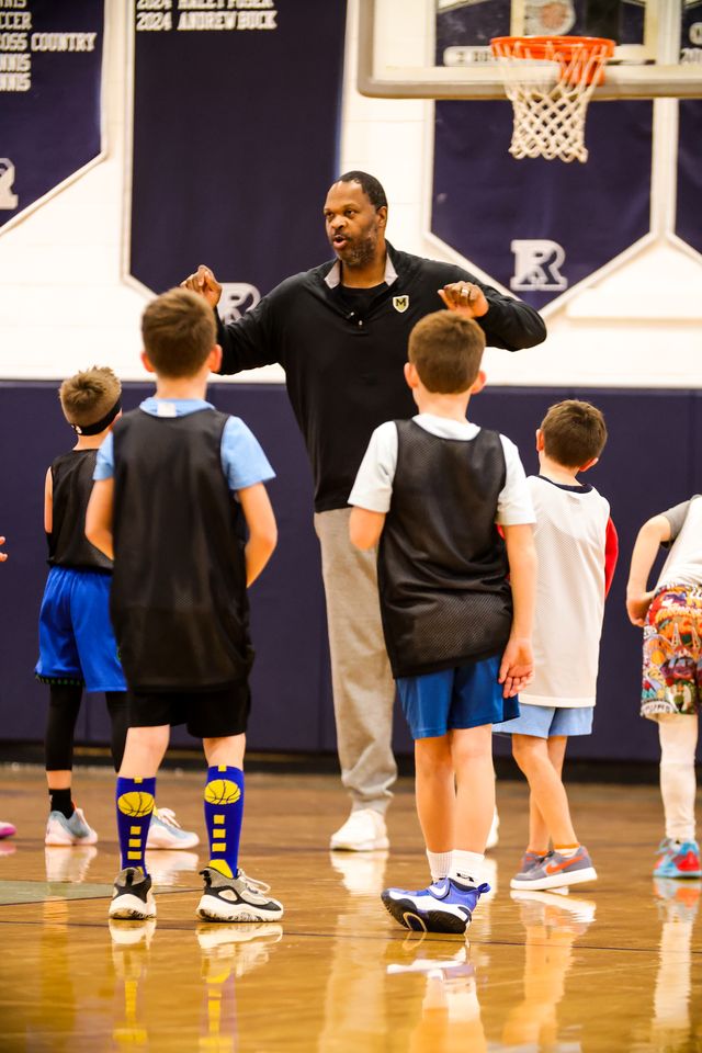 Tahj Holden talking with players in a huddle
